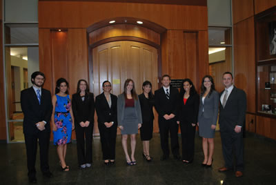 Photo of people in front of door all dressed in professional attire.